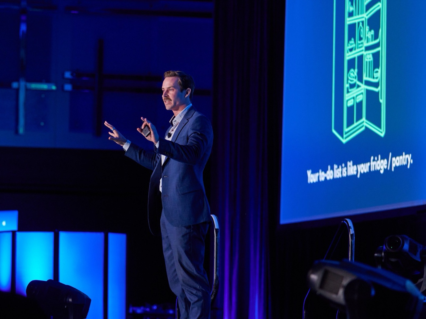 Lucas Miller on stage in front of a slide that reads: Your to-do list is like your fridge or pantry.